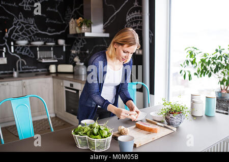 Giovane donna cottura a casa. Foto Stock