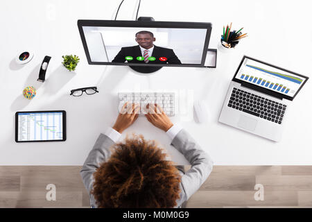 Angolo di Alta Vista di imprenditrice Videoconferenza con il collega sul computer Foto Stock