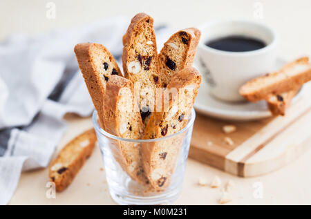 Italian biscotti con mirtilli e mandorle e la tazza di caffè sullo sfondo Foto Stock