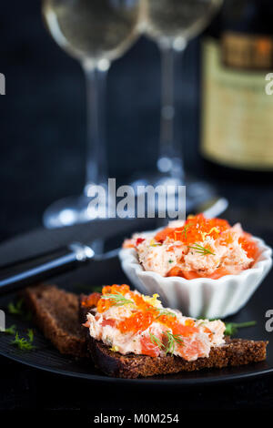 Pâté di salmone (rillettes) con caviale rosso servito con fette di pane Foto Stock