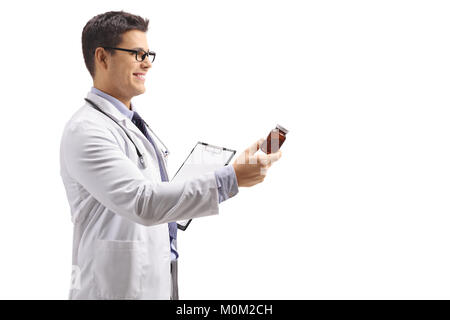 Medico con una clipboard dando una bottiglia di pillole isolati su sfondo bianco Foto Stock