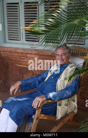 L'India,Goa,Coco Beach,Richard Holkar,figlio del maharadjah di Indore,salotto in una sedia nel suo hotel di lusso Ahilya dal mare Foto Stock