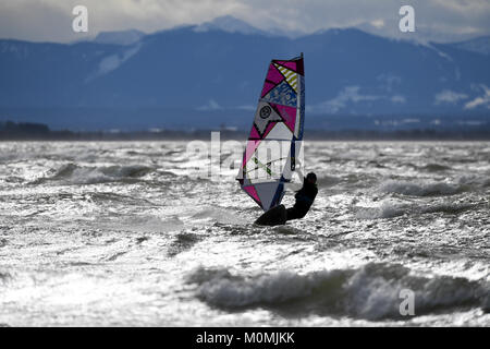 Herrsching, Germania. 18 gennaio, 2018. Durante i venti forti, un surfer Cavalca le onde forti causati dalla tempesta davanti "Friederike' sul lago Ammersee in Herrsching, Germania, 18 gennaio 2018. Credito: Felix Hörhager/dpa/Alamy Live News Foto Stock