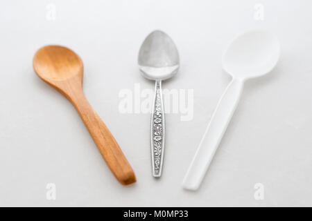 Cucchiaio di legno, plastica cucchiaio e cucchiaino di metallo Foto Stock