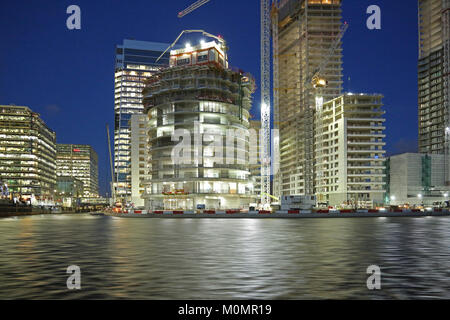 Vista del tramonto della costruzione di nuove torri residenziali in London Canary Wharf district. Mostra un parco auto sviluppo nel centro. Foto Stock