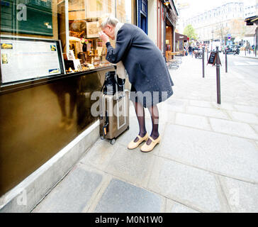 Parigi, Francia. Donna anziana cercando nella vetrina di un negozio. Foto Stock