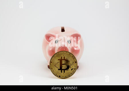 Bitcoin medaglia d'oro e piggy box, suino isolati in uno sfondo bianco Foto Stock