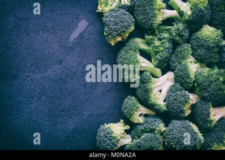 Brassica oleracea. Tagliare i broccoli su un sfondo di ardesia. Vintage filtro applicato Foto Stock