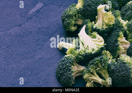 Brassica oleracea. Tagliare i broccoli su un sfondo di ardesia. Vintage filtro applicato Foto Stock