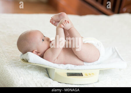 Neonato sulla scala di pesatura Foto Stock