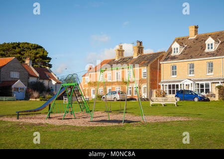 Case che si affacciano su un parco giochi o parco giochi, Walberswick, Suffolk REGNO UNITO Foto Stock