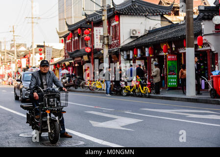 Shanghai, Cina. Un uomo su un ciclomotore attende in corrispondenza di una luce di colore rosso su una tipica strada laterale in Cina a Shanghai. Credito: Benjamin Ginsberg Foto Stock