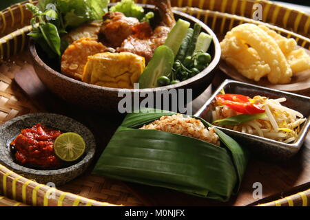 Nasi Tutug Oncom, il Sundanese piatto di riso con fagioli di soia fermentati; servita con una varietà di piatti laterali Foto Stock