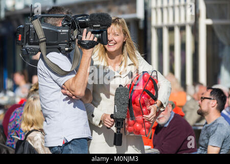 Femmina TV presentatore ridendo e sorridente sul lavoro, su un'outside broadcast nel Regno Unito. Foto Stock