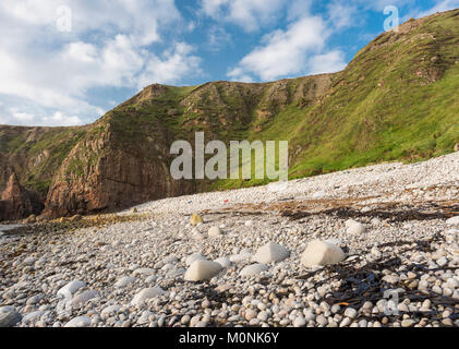 Scogliera e spiaggia di ciottoli in una insenatura a Bloody Foreland, a nord-ovest di Punta della Contea di Donegal, Irlanda Foto Stock