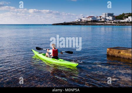 Un ragazzo adolescente in un kayak a Punta Prima , Minorca , Isole Baleari , Spagna Foto Stock