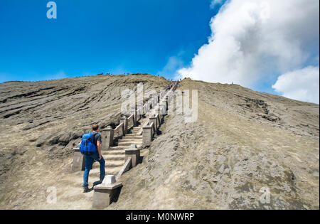 Giovane uomo su per le scale per il bordo del cratere del vulcano fumatori Gunung Bromo,Parco Nazionale Bromo-Tengger-Semeru,Java Foto Stock