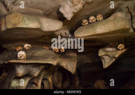 I teschi e le ossa sparsi sul pavimento e appesi al soffitto a Londa grotta, Rantepao Tana Toraja. Foto Stock