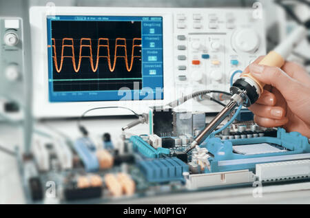 Il tecnico ripara curcuit elettronico di bordo nel centro di servizio Foto Stock