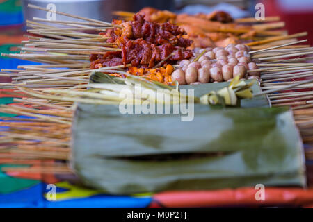 Un preferito Street snack alimentare nelle Filippine,spiedini di carne che viene poi alla griglia su un barbecue esterno. Foto Stock