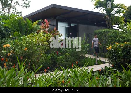 Costa Rica,osa peninsula,memeber del personale dell'ecolodge Kura ville design,nella parte anteriore di un contemporaneo design suite nel mezzo di un giardino tropicale Foto Stock