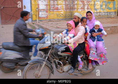 BUNDI, Rajasthan, India - 10 dicembre 2017: Trasporto locale con un sorridente famiglia che viaggiano su una motocicletta per le strade della città vecchia Foto Stock