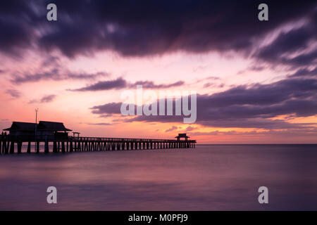 Moody sera oltre la pesca del molo e la costa del Golfo di Napoli, Florida, Stati Uniti d'America Foto Stock