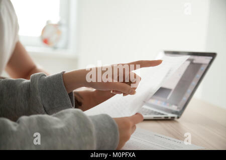 Femmina di puntamento a mano sul documento prestando attenzione a importanti t Foto Stock