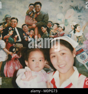 Polaroid di un infermiere sorridente con un bambino davanti a un poster con il caro leader, Sud Pyongan Provincia, Nampo, Corea del Nord Foto Stock