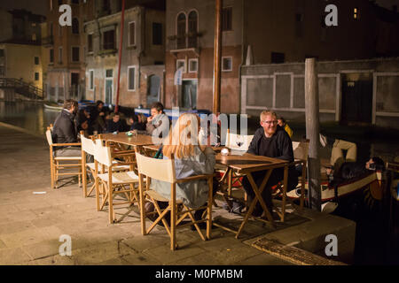 Cena all'aperto di notte lungo un canale di Venezia Foto Stock