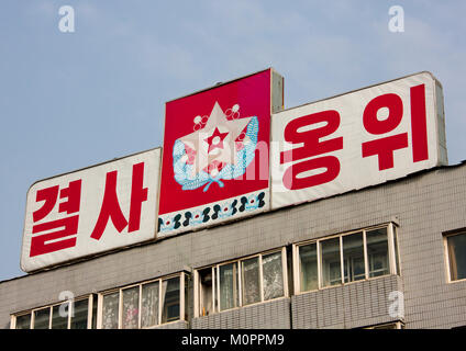 Tabellone di propaganda con la bandiera del comandante supremo della Korean esercito del popolo sulla parte superiore di un edificio, Provincia di Pyongan, Pyongyang, Corea del Nord Foto Stock