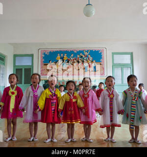 Corea del Nord le ragazze che cantano durante una lezione di classe in una scuola primaria, Sud Pyongan Provincia, Chongsan-ri Cooperativa, Corea del Nord Foto Stock