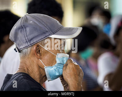 Guinobatan, Albay, Filippine. 24 gen 2018. Un uomo si regola il suo respiratore a filtro durante una cenere vulcanica caduta in Guinobatan. Il vulcano Mayon ha continuato ad eruttare martedì sera e mercoledì forzando la Albay governo provinciale di ordinare più evacuazioni. Credito: ZUMA Press, Inc./Alamy Live News Foto Stock