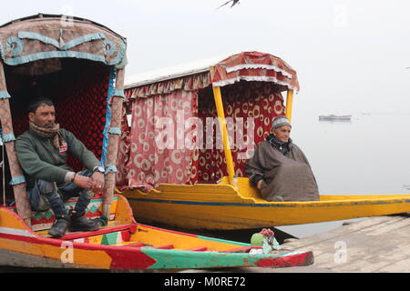 Srinagar Kashmir. 23 gen 2018. Giallo shikaras, piccola di acqua di legno barche taxi, attendere per i clienti durante il freddo e la nebbia di mattina sulla rive del dal Lago. Credito: Arfath Naseer/ Pacifico premere/Alamy Live News Foto Stock