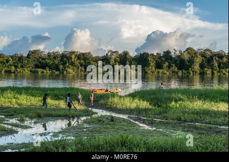 I bambini giocano sulla riva del fiume vicino al villaggio. Declino e fine del giorno. Giugno 26, 2012 nel villaggio, Nuova Guinea, Indonesia Foto Stock