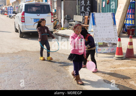 Marzo 2014 - Qingdao, Cina - i bambini a giocare in strada nel quartiere povero di Shandongtou Foto Stock