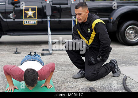 Il personale Sgt. Frank Keffales, un espositore con il Mobile presentano Company, Fort Knox, Kentucky, conta pushups per uno studente presso l'esperienza GoArmy zona durante il 2018 U.S. Esercito ciotola All-American settimana al di fuori dell'Alamodome in San Antonio, Texas, 5 gennaio 2018. L'esercito zona esperienza dimostra l impegno dell esercito in America a favore della gioventù illustrando diversi aspetti nella vita militare. Foto Stock