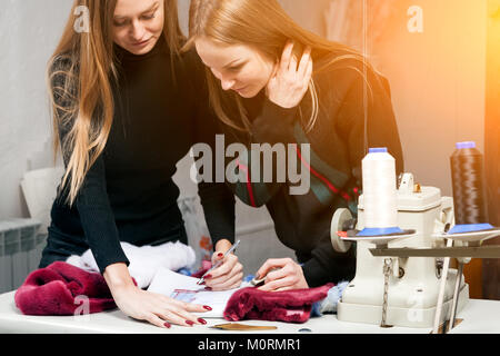 Due giovani donne furriers stanno discutendo di come propriamente tagliato pelliccia naturale per rendere una donna di pelliccia. Il processo per la fabbricazione di una donna di pelliccia Foto Stock