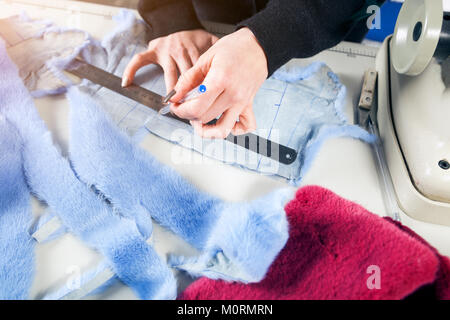 Il processo per la fabbricazione di una donna di pelliccia. Un close-up di una giovane donna pellicciaio vernice blu di un cappello di pelliccia per la realizzazione di una donna di pelliccia Foto Stock