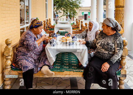 Un piccolo gruppo di donne uzbeke di mangiare il pranzo presso una caffetteria all'interno del Bazaar Principale, Samarcanda, Uzbekistan Foto Stock