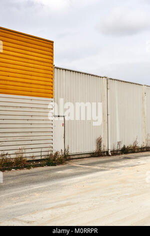 Abbandonato il magazzino vuoto con giallo / arancio pannellatura. Foto Stock