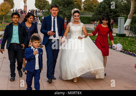 Un 'Just Married " Coppia Giovane arrivano al Registan complesso per le loro foto di nozze, Samarcanda, Uzbekistan Foto Stock