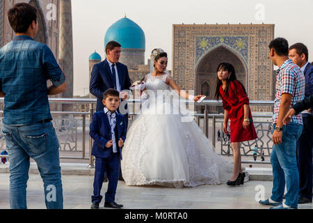Un 'Just Married " Coppia Giovane arrivano al Registan complesso per le loro foto di nozze, Samarcanda, Uzbekistan Foto Stock