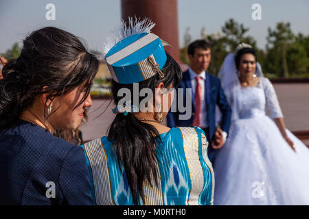 Un 'appena sposato' giovane arrivano al Registan complesso per le loro foto di nozze, il Registan, Samarcanda, Uzbekistan Foto Stock