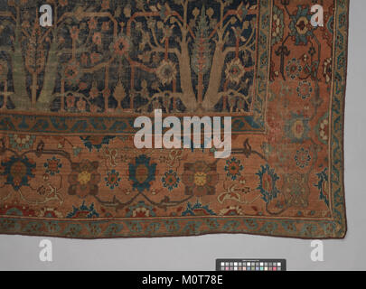 Questo tappeto, caratterizzato da un design ad albero ripetuto, mette in mostra la tradizionale maestria artigianale e il design. I suoi motivi intricati e i colori vivaci sono caratteristici dei tessuti tessuti di periodi storici, spesso utilizzati come oggetti decorativi per la casa. Foto Stock
