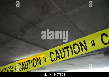 Il nastro di attenzione è ampiamente utilizzato come misura di sicurezza in vari ambienti per avvisare le persone di condizioni pericolose. Il nastro dai colori vivaci, spesso giallo con strisce nere, è comunemente utilizzato nelle zone di costruzione, nei cantieri di incidenti o nelle aree che richiedono un accesso limitato. Serve come avvertimento visivo per proteggere le persone da potenziali pericoli. Foto Stock