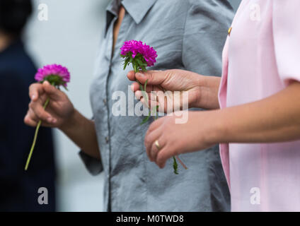 Nord Coreani portando fiori a pagare rispetto ai leader del Mansudae art studio, Provincia di Pyongan, Pyongyang, Corea del Nord Foto Stock