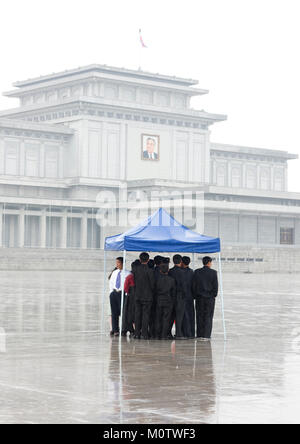 Corea del Nord la gente sotto la pioggia nel palazzo Kumsusan del sole che serve come il mausoleo di Kim Il-sung e Kim Jong-il, Provincia di Pyongan, Pyongyang, Corea del Nord Foto Stock