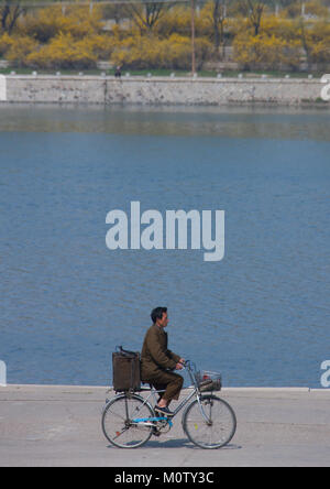 Corea del Nord uomo in bicicletta lungo il fiume Taedong, Provincia di Pyongan, Pyongyang, Corea del Nord Foto Stock