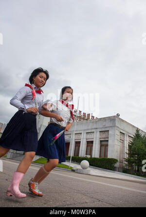 Nord coreano pionieri andando a pagare rispetto al caro leader a Mansudae art studio, Provincia di Pyongan, Pyongyang, Corea del Nord Foto Stock